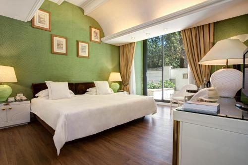 罗马拜伦勋爵酒店 - 世界小型豪华酒店集团的卧室配有白色的床和绿色的墙壁