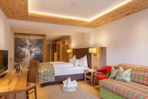 伊施格尔奥林匹亚酒店的酒店客房,配有床和沙发