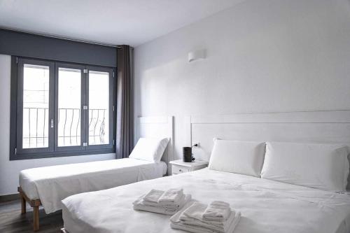 奥罗塞伊Domo Orise Alloggio in pieno centro的一间白色卧室,配有两张床和窗户