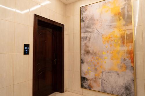 艾卜哈فندق رحيب للشقق المخدومة Rahib Suites的门旁的走廊上挂着一幅大画