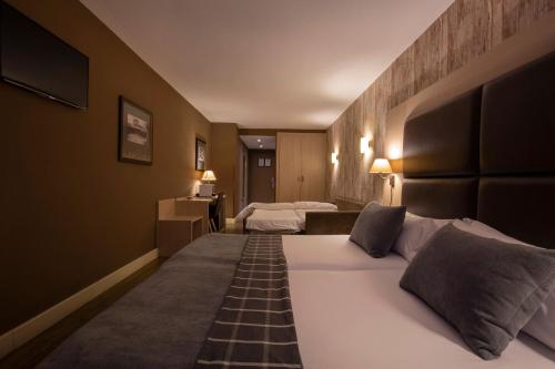 索尔德乌Hotel Himàlaia Soldeu的酒店客房设有两张床和电视。