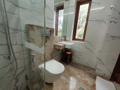 孟买Capital Hotel的浴室配有卫生间、淋浴和盥洗盆。