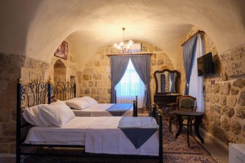 马尔丁MİRSTONE TARİHİ KONAK的一间卧室设有两张床和窗户。