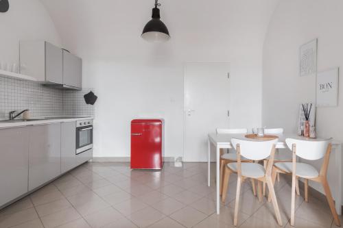 布拉格Attic Apartment in Smíchov by Prague Days的厨房配有红色冰箱、桌子和椅子