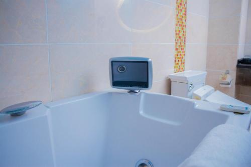 卢萨卡Best Western Plus Paramount Hotel的浴室配有浴缸顶部的电视