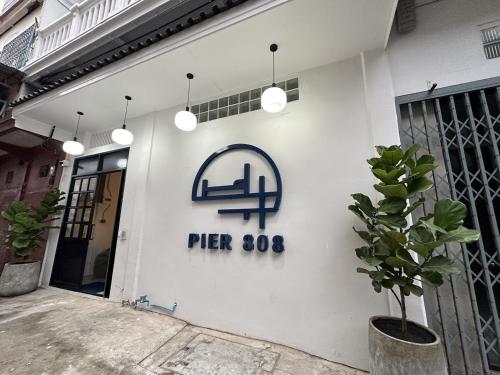 曼谷PIER 808 Hostel的白色的建筑,旁边标有标志