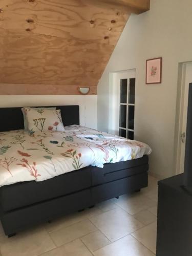 NieuwlandeDe Dagloner的一间卧室设有一张木天花板床。