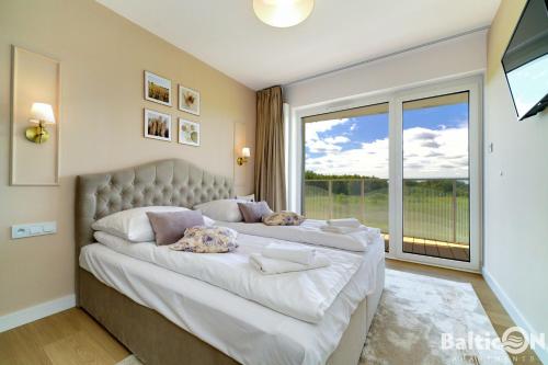 科沃布热格Apartamenty BalticON Polanki Aqua的一间卧室设有一张大床和大窗户