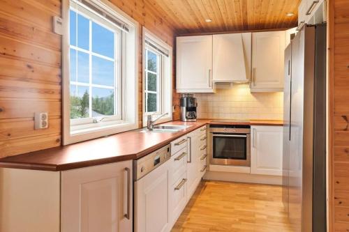 阿尔塔Hytte i flott natur的厨房配有白色橱柜和木制天花板