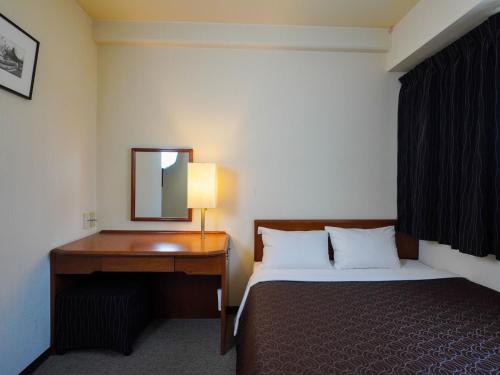 福冈Plaza Hotel Tenjin - Vacation STAY 40083v的一间卧室配有一张床和一张带镜子的书桌