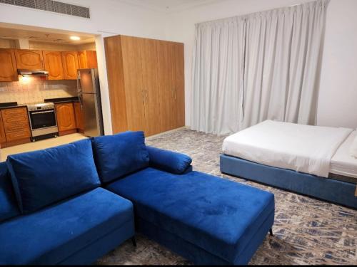 迪拜Havana Holiday Homes Oud Metha的客厅配有蓝色的沙发和床。