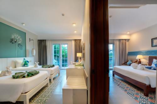 会安Lantana Boutique Hoi An Hotel的一间酒店客房,房间内设有三张床