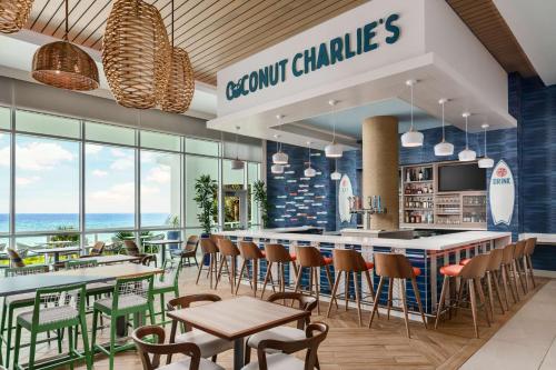 巴拿马城海滩Hyatt Place Panama City Beach - Beachfront的餐厅设有酒吧,配有桌椅