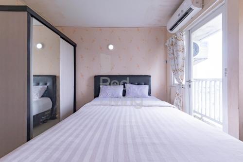 加拉旺RedLiving Apartemen Grand Sentraland - Dragon Apartel Tower Pink的窗户客房内的一张大白色床