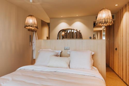 米德尔克尔克BONK suites的一间卧室配有一张带白色床单和两盏灯的床。