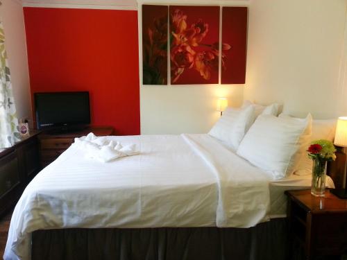 Claygate罗斯米德宾馆的卧室配有白色的床和电视。