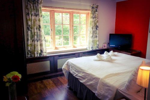 Claygate罗斯米德宾馆的卧室配有一张大白色床和窗户