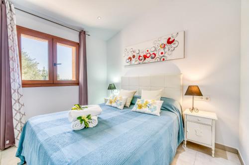 布格El Rafal de Son Alberti的一间卧室设有蓝色的床和窗户。