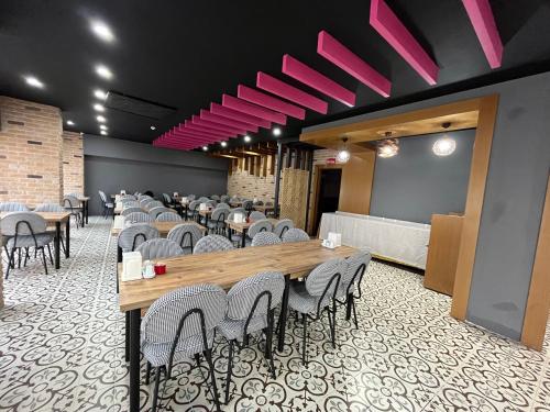 塞尔丘克Nobel Boutique Hotel的用餐室配有桌椅和粉红色的灯光