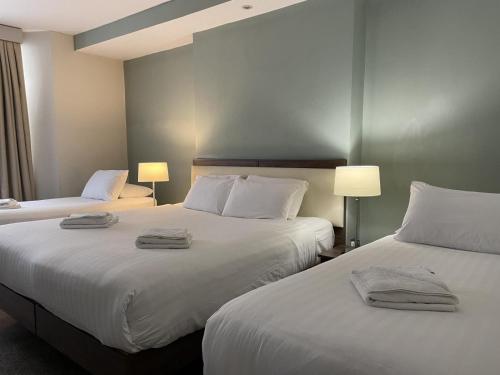 伦敦海德公园精品酒店的两张位于酒店客房的床,配有毛巾