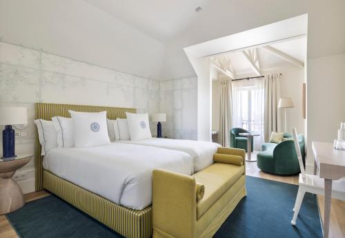 波尔图One Shot Palácio Cedofeita的酒店客房带一张大床和一把椅子