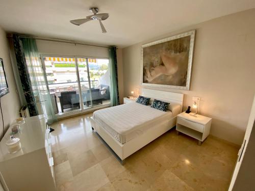 马贝拉Apartamento con vistas y terraza en Guadalmina Marbella的卧室配有一张床,墙上挂有绘画作品