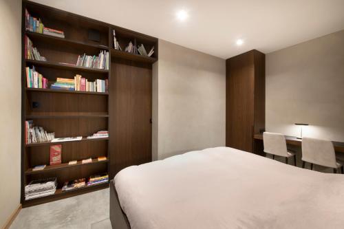 奥德海文利Nuit Blanche的一间卧室设有一张床和一个书架