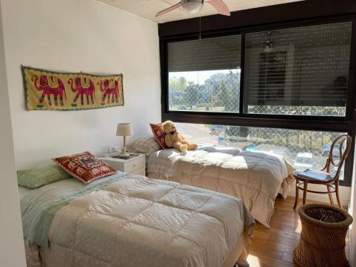 蒙得维的亚Precioso apartamento en moderno edificio的一间卧室设有两张床,床上配有泰迪熊