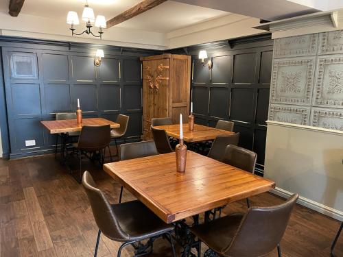 克拉珀姆New Inn Hotel的用餐室配有木桌和椅子