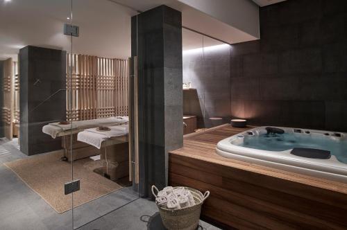 米克诺斯城Bill & Coo Mykonos -The Leading Hotels of the World的一间带按摩浴缸和水槽的浴室
