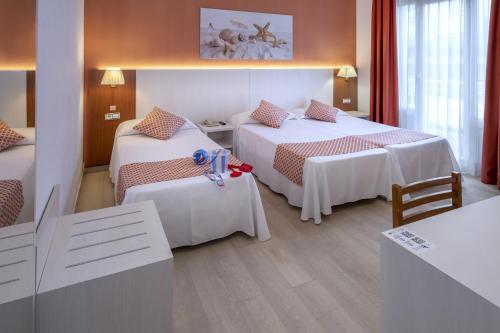 卡里拉GHT巴尔梅斯公寓式酒店的酒店客房设有两张床和一张桌子。