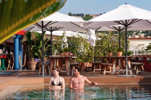 尼斯AC Hotel by Marriott Nice的两个男人在一家酒店的游泳池里