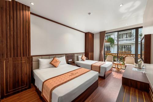 下龙湾Harmony HaLong Hotel的酒店客房配有两张床和一张书桌