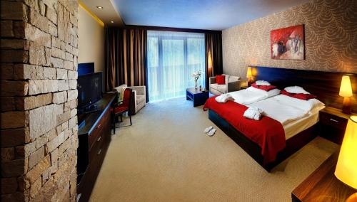 迪马诺卡多林纳乔泊科健康酒店的酒店客房,配有一张带红色毯子的床