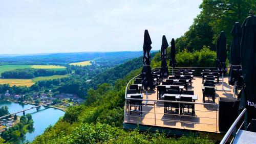 普罗丰德维耶LES 7 MEUSES - Restaurant & Hébergements HÔTELIERS - INSOLITES - WELLNESS - GÎTES的一间位于山边的餐厅,俯瞰着河流
