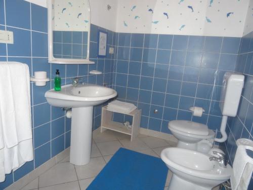 萨尔雷Ca Greta F - Sea View Apartments的蓝色瓷砖浴室设有卫生间和水槽