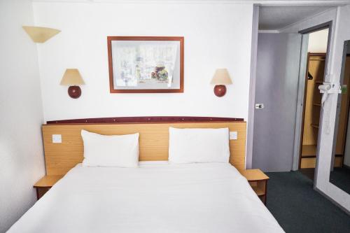 朗科恩钟楼朗科恩酒店的卧室配有一张带两个枕头的大白色床