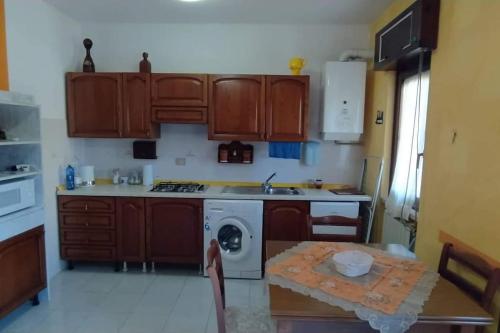 桑格罗堡Casa vancanze con camino的厨房配有木制橱柜和1张带洗衣机的桌子。