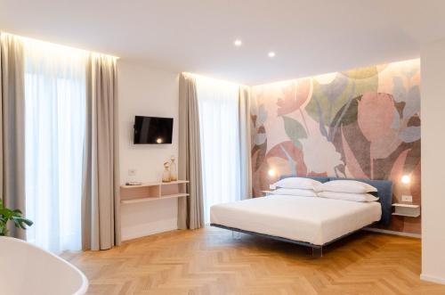 陶尔米纳Neró Rooms的卧室配有一张床,墙上挂有绘画作品