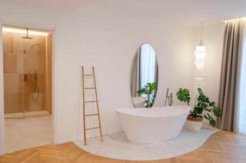 陶尔米纳Neró Rooms的一间带白色浴缸和梯子的浴室