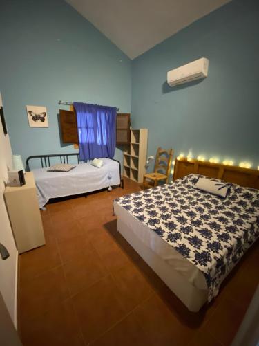 马拉加Casa Rural Los Almendros的一间卧室设有两张床和蓝色的墙壁