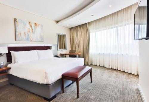 约翰内斯堡约翰内斯堡罗斯班克假日酒店的卧室设有一张白色大床和一扇窗户。