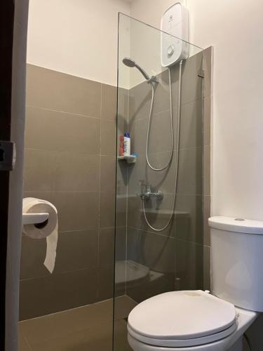 CogonMactan Cebu Guesthouse - ideal for family or friends的浴室设有玻璃淋浴间和卫生间