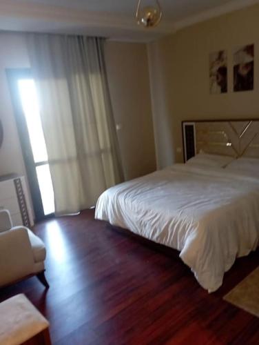 Sheikh Zayedبيفرلي هيلز ويست تاون الشيخ زايد的卧室配有白色的床,铺有木地板