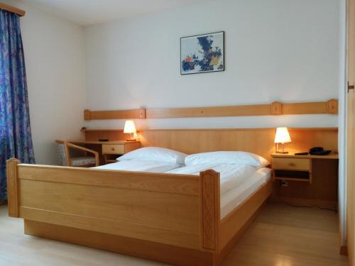 萨梅丹特米纳斯酒店的一间卧室配有一张带两盏灯的大木床。