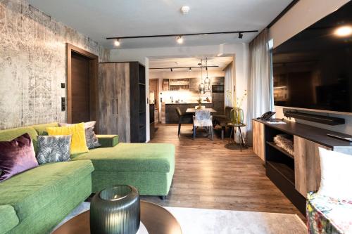 圣安东阿尔贝格Apart Sailers的客厅配有绿色沙发和桌子