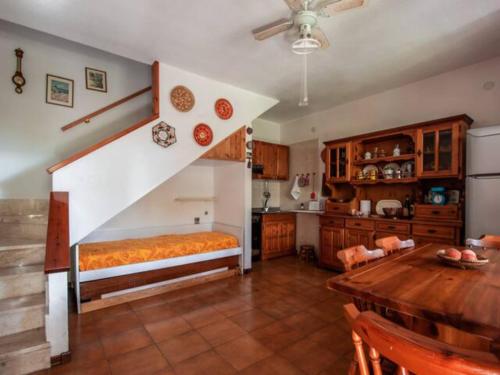 圣卢里亚Casa a schiera con giardino a pochi passi dal mare的一间设有楼梯和桌子的厨房