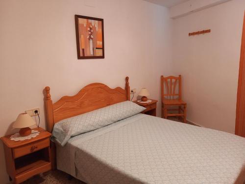 Villanueva de ViverCasa Esteban的一间卧室配有一张床和两张桌子及两张椅子
