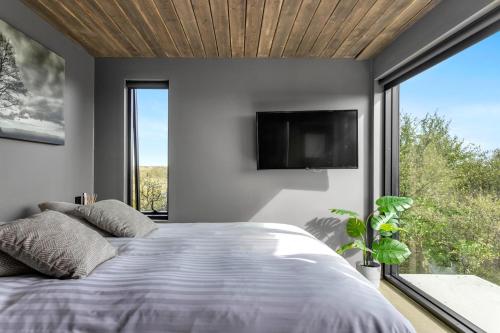 塞尔福斯Luxurious 4BR Summerhouse with Hot Tub and Sauna的一间卧室设有一张床和一个大窗户