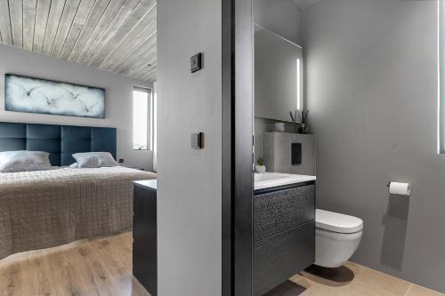 塞尔福斯Luxurious 4BR Summerhouse with Hot Tub and Sauna的浴室设有床、卫生间和水槽。